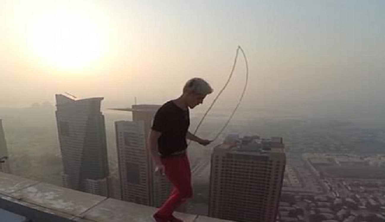 على ارتفاع ٩٠٠ قدم.. شاب يقفز بحركات جنونية على حافة ناطحة سحاب في دبي