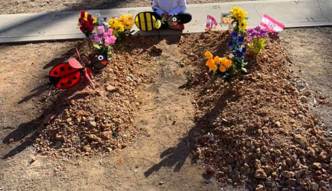 ماتوا حرقا.. صورة مؤثرة لطفلة تجلس بين قبري أشقائها
